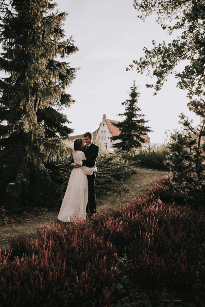 Jesienna para młoda pozująca pośród wrzosów w ogrodzie Pałacu w Bielawie