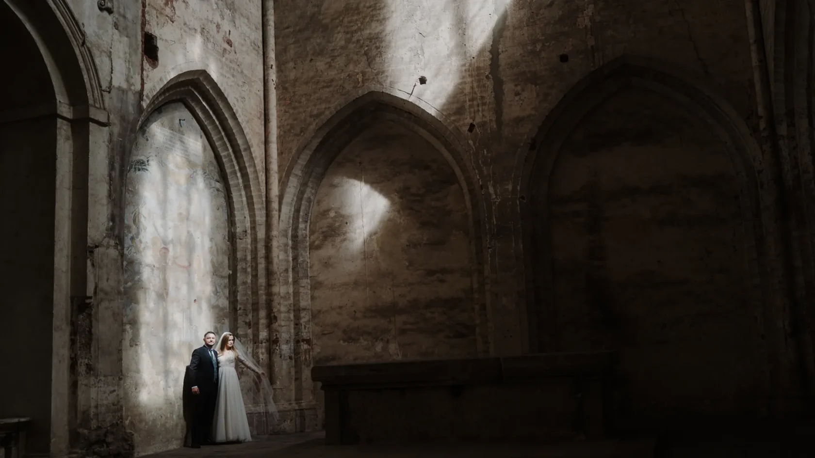 Para młoda oświetlona słońcem w kościele w opactwie cystersów w Lubiążu