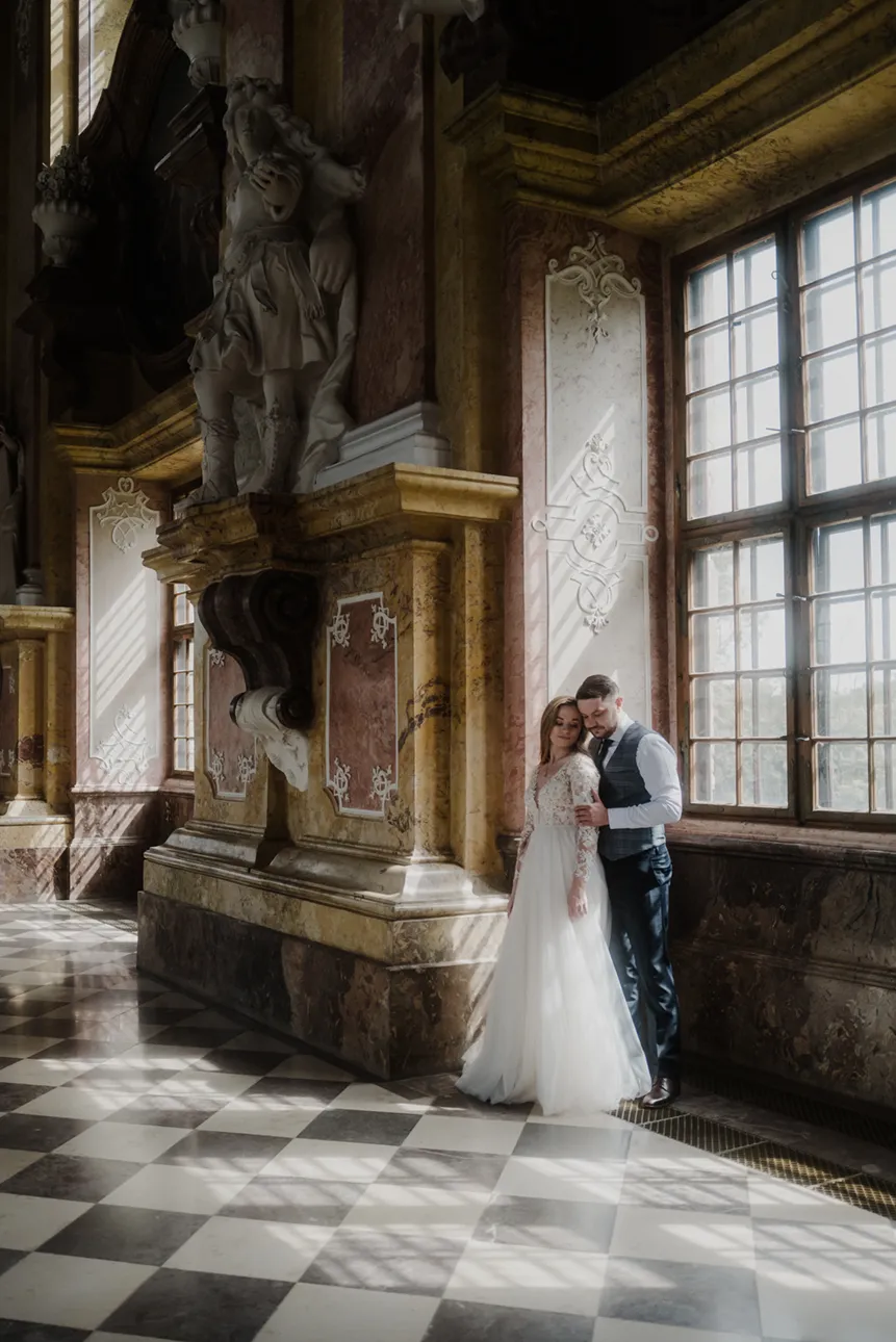 Para młoda pozuje na tle okna w opactwie cystersów w lubiążu