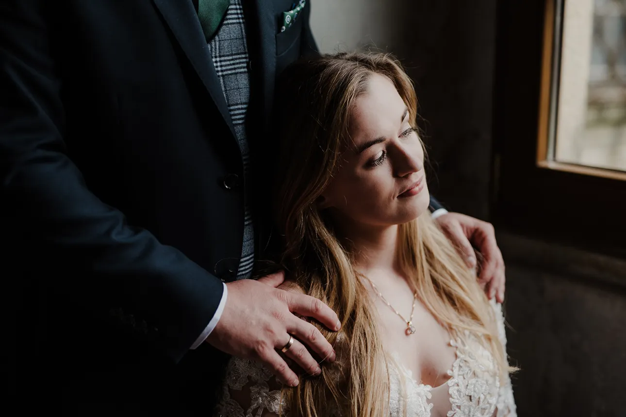 Pan młody obejmuje pannę młodą w czasie sesji zdjęciowej w opactwie cystersów w Lubiążu