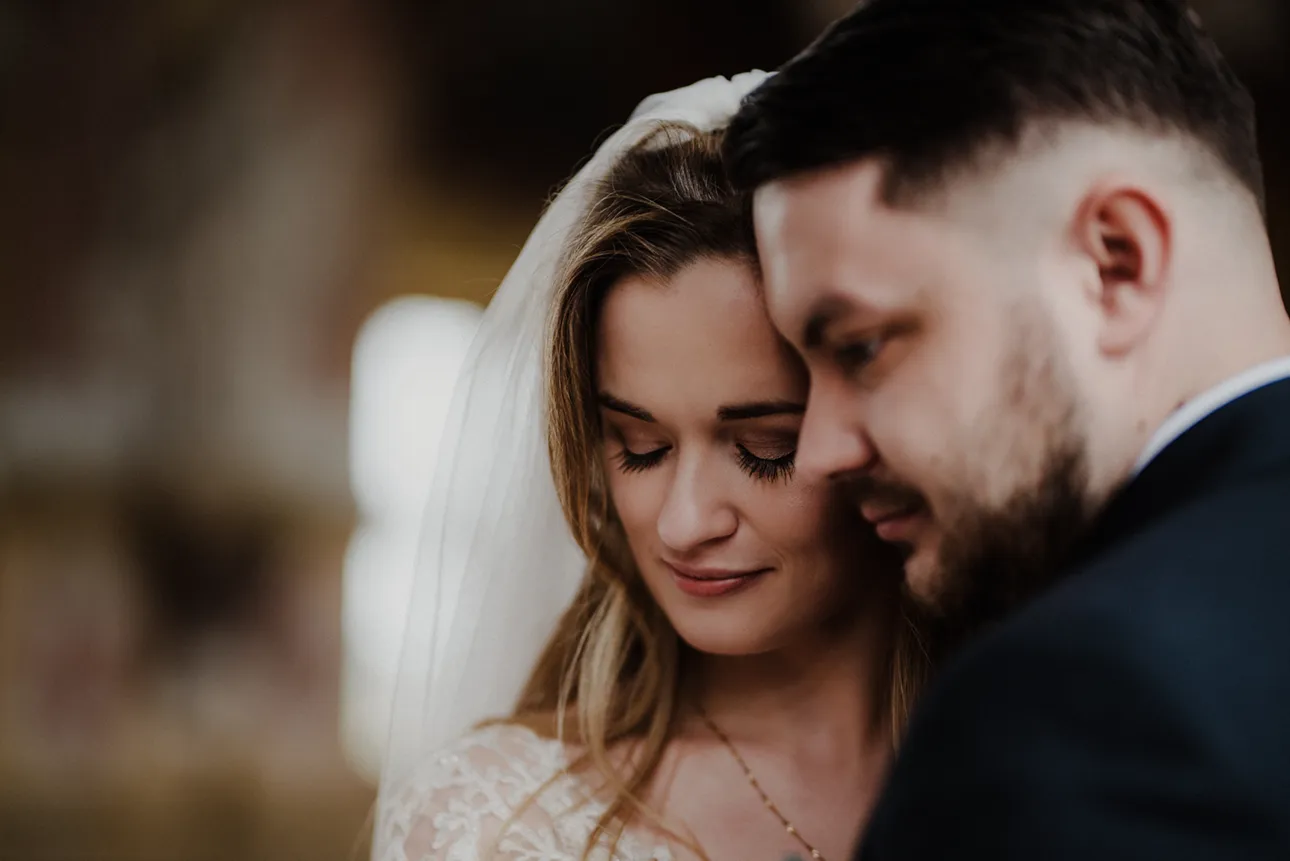 Przytulająca się para młoda w czasie sesji ślubnej w Lubiążu