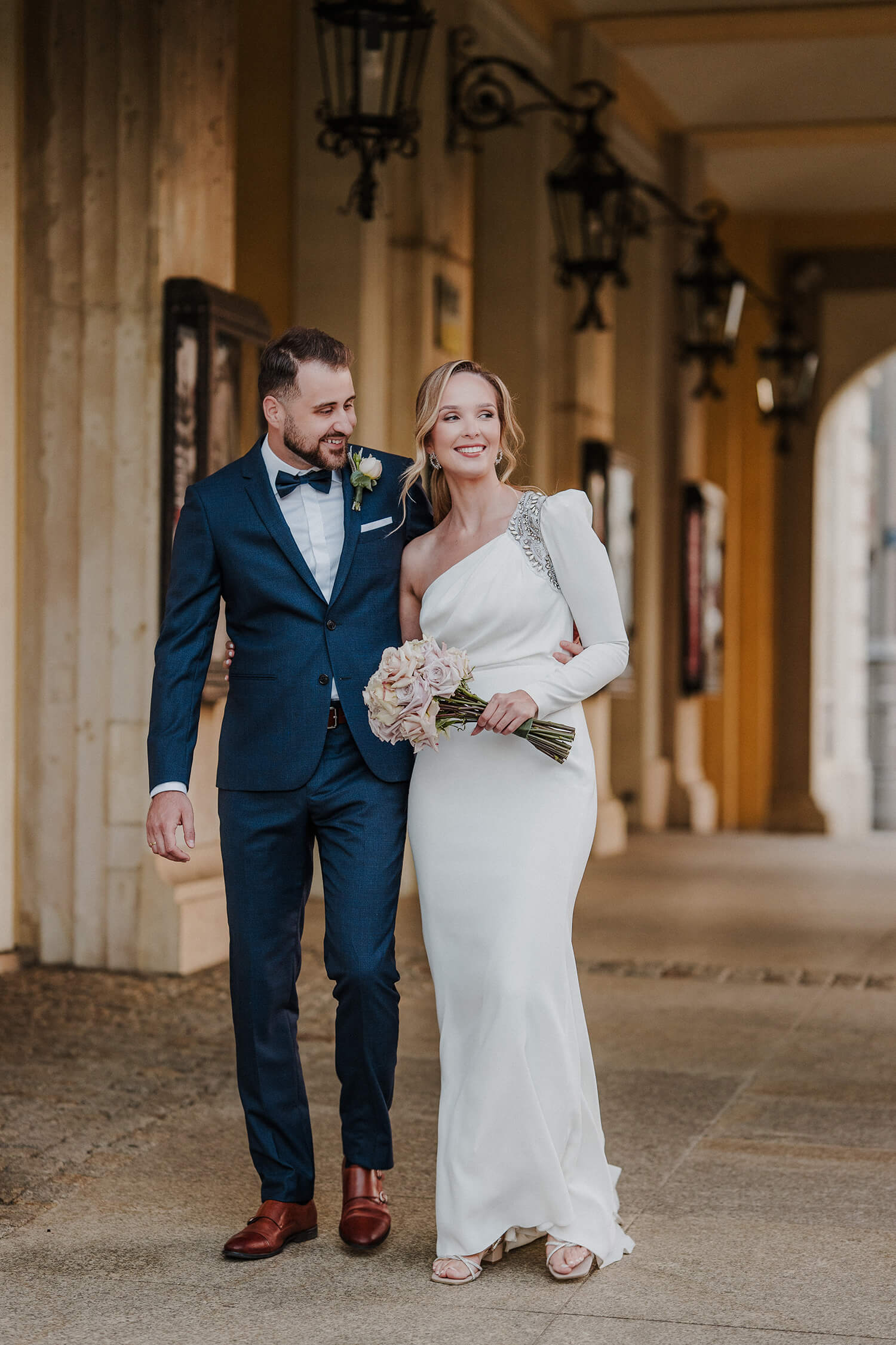 Para młoda uchwycona na naturalnej fotografii, spacerująca obok Opery Wrocławskiej.