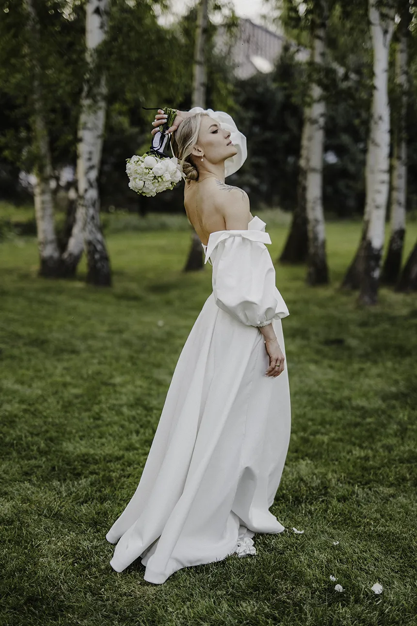 Panna młoda pozuje z bukietem w czasie krótkiej sesji zdjęciowej w dniu ślubu